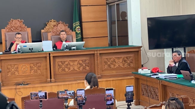 Nikita Mirzani menatap tajam dan tertawa saat mendengar kesaksian Reza Gladys. [Suara.com/Tiara Rosana]