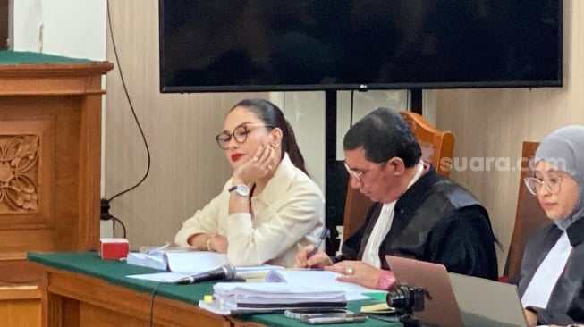 Nikita Mirzani menatap tajam dan tertawa saat mendengar kesaksian Reza Gladys. [Suara.com/Tiara Rosana]