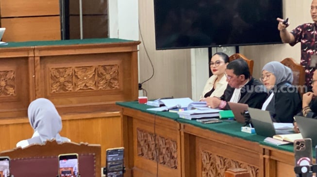 Nikita Mirzani menatap tajam dan tertawa saat mendengar kesaksian Reza Gladys. [Suara.com/Tiara Rosana]