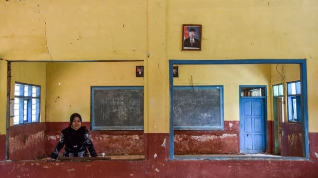 Seorang guru menunjukkan ruang kelas yang rusak di SD Negeri Mandalawangi, Desa Lengkongbarang, Kecamatan Cikatomas, Kabupaten Tasikmalaya, Jawa Barat, Kamis (24/7/2025). [ANTARA FOTO/Adeng Bustomi/foc]