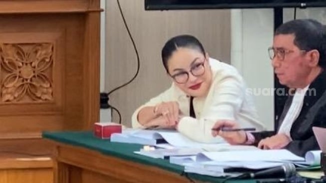 Nikita Mirzani menatap tajam dan tertawa saat mendengar kesaksian Reza Gladys. [Suara.com/Tiara Rosana]