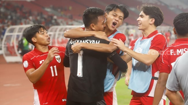 Pemain Timnas Indonesia U-23 memeluk Kiper Muhammad Ardiansyah usai memenangkan pertandingan semifinal Piala AFF U-23 2025 melawan Thailand U-23 di Stadion Utama Gelora Bung Karno (SUGBK), Senayan, Jakarta, Jumat (25/7/2025). [Suara.com/Alfian Winanto]