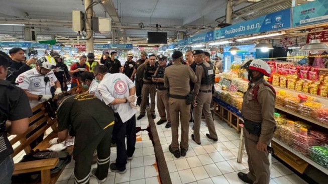 Pemeriksaan jenazah pelaku penembakan di Pasar Or Tor Kor. Petugas penyelamat memeriksa jenazah pelaku penembakan di hadapan polisi di pasar Or Tor Kor, Distrik Chatuchak, Bangkok, pada hari Senin. [Bangkok Post]