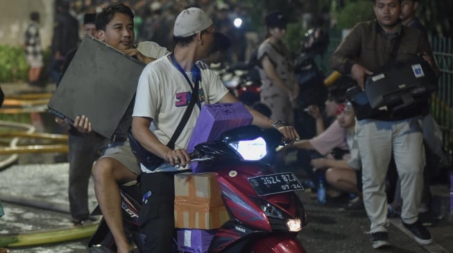 Pedagang menyelamatkan barang dagangan pada kebakaran di Pasar Taman Puring, Kebayoran Baru, Jakarta Selatan, Senin (28/7/2025). [ANTARA FOTO/ Fakhri Hermansyah/nz]