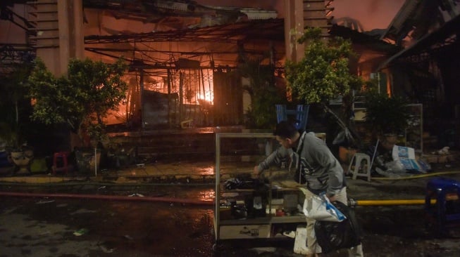 Pedagang menyelamatkan barang dagangan pada kebakaran di Pasar Taman Puring, Kebayoran Baru, Jakarta Selatan, Senin (28/7/2025). [ANTARA FOTO/ Fakhri Hermansyah/nz]