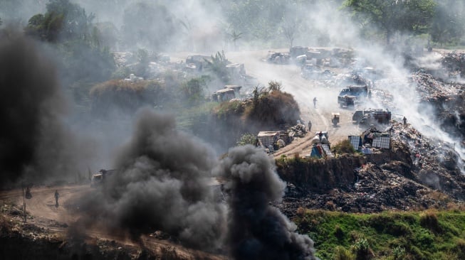 Pemulung memilah sampah di antara kepulan asap pembakaran sampah di tempat pembuangan akhir (TPA) ilegal, Rowosari, Tembalang, Jawa Tengah, Selasa (29/7/2025). [ANTARA FOTO/Aprillio Akbar/tom]