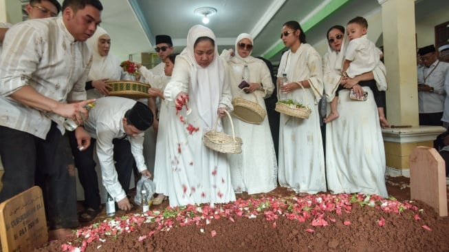 Istri Menteri Agama periode 2009-2014 Suryadharma Ali, Wardhatul Asriah (tengah) bersama keluarga menaburkan bunga dan berdoa di pemakaman area Pondok Pesantren Miftahul Ulum, Cikarang Barat, Kabupaten Bekasi, Jawa Barat, Kamis (31/7/2025).[ANTARA FOTO/ Fakhri Hermansyah/rwa]