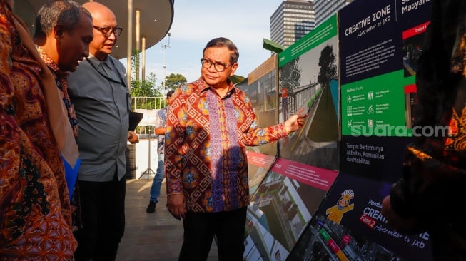 Gubernur DKI Jakarta, Pramono Anung melihat peta rencana pembangunan saat kegiatan susur sungai di Jakarta, Kamis (31/7/2025). [Suara.com/Alfian Winanto]