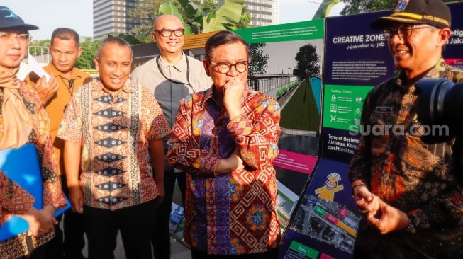Gubernur DKI Jakarta, Pramono Anung melihat peta rencana pembangunan saat kegiatan susur sungai di Jakarta, Kamis (31/7/2025). [Suara.com/Alfian Winanto]