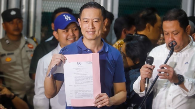 Terdakwa kasus dugaan korupsi impor gula Thomas Trikasih Lembong atau Tom Lembong menunjukan  surat pembebasan dirinya saat meninggalkan Lembaga Permasyarakatan (LP) Cipinang, Jakarta, Jumat (1/8/2025). [Suara.com/Alfian Winanto]