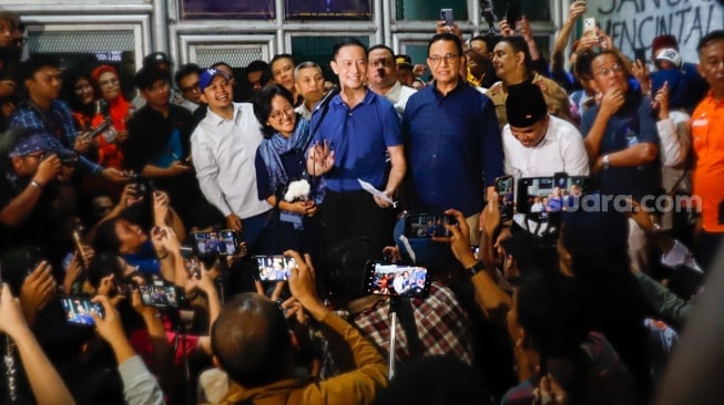 Terdakwa kasus dugaan korupsi impor gula Thomas Trikasih Lembong atau Tom Lembong (tengah) ditemani istrinya Ciska Wihardja (kiri) dan Anies Baswedan (kanan) menyapa awak media dan pendukungnya saat meninggalkan Lembaga Permasyarakatan (LP) Cipinang, Jakarta, Jumat (1/8/2025). [Suara.com/Alfian Winanto]