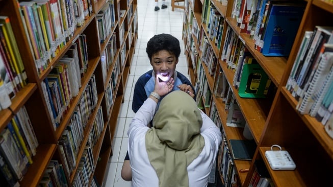 Tenaga kesehatan memeriksa kondisi gigi pelajar saat pelaksanaan Cek Kesehatan Gratis (CKG) di SMPK Penabur Gading Serpong, Kabupaten Tangerang, Banten, Senin (4/8/2025). [ANTARA FOTO/Putra M. Akbar/nym]