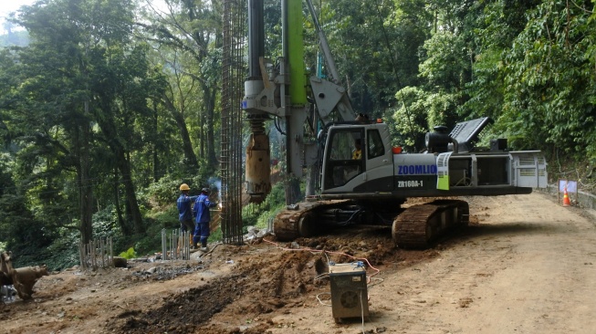 Petugas menggunakan alat berat saat memasang rangka besi pondasi untuk perbaikan jalan nasioal Gunung Gumitir, Jember, Jawa Timur, Minggu (3/8/2025). [ANTARA FOTO/Seno/rwa]