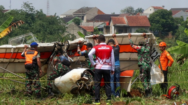 Petugas Basarnas bersama prajurit TNI AU berusaha mengevakuasi bangkai pesawat latih sipil Microlight Fixedwing Quicksilver GT500 dengan register PK-S126 yang jatuh di perkebunan warga, TPU Astana, Ciampea, Kabupaten Bogor, Jawa Barat, Minggu (3/8/2025). [ANTARA FOTO/Fadli/Arf/rwa]
