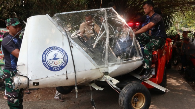 Prajurit TNI AU mengevakuasi bangkai pesawat latih sipil Microlight Fixedwing Quicksilver GT500 dengan register PK-S126 yang jatuh di perkebunan warga, TPU Astana, Ciampea, Kabupaten Bogor, Jawa Barat, Minggu (3/8/2025). [ANTARA FOTO/Fadli/Arf/rwa]
