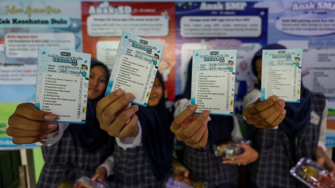 Sejumlah siswi menunjukan kartu peserta cek kesehatan saat peluncuran program Cek Kesehatan Gratis (CKG) untuk anak sekolah di SMP Negeri 1 Padangan, Bojonegoro, Jawa Timur, Senin (4/8/2025). [ANTARA FOTO/Muhammad Mada/YU]