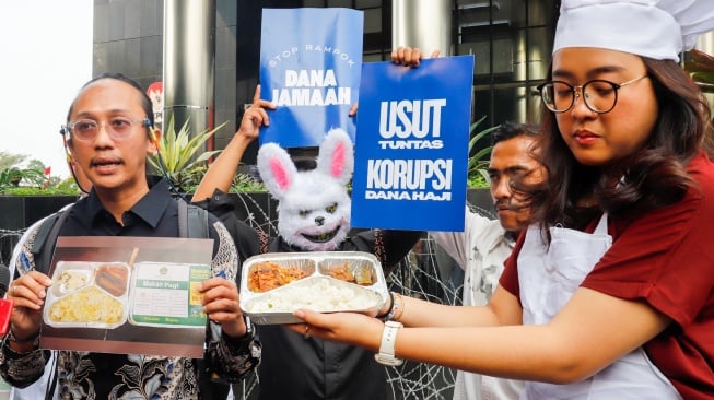 Pegiat antikorupsi dari Indonesia Corruption Watch (ICW) menggelar aksi seusai melaporkan kasus dugaan korupsi penyelenggaraan haji 1446H/2025 di Gedung Merah Putih KPK, Jakarta, Selasa (5/8/2025). [Suara.com/Alfian Winanto]