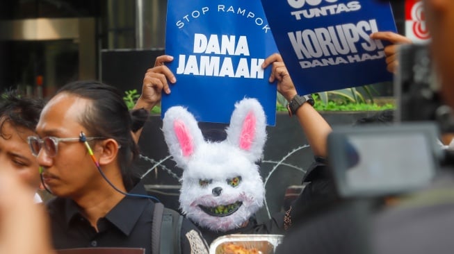 Pegiat antikorupsi dari Indonesia Corruption Watch (ICW) menggelar aksi seusai melaporkan kasus dugaan korupsi penyelenggaraan haji 1446H/2025 di Gedung Merah Putih KPK, Jakarta, Selasa (5/8/2025). [Suara.com/Alfian Winanto]