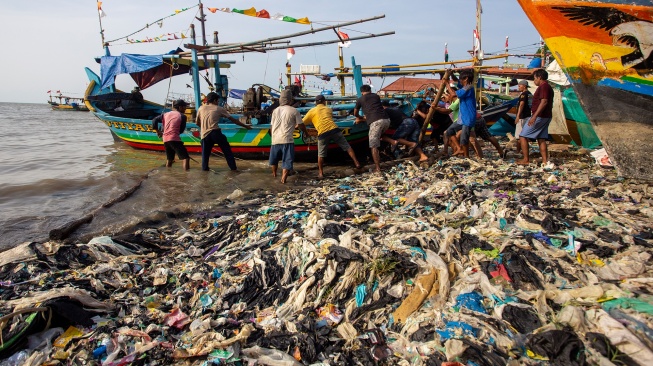 Sejumlah nelayan menarik perahu yang terhalang tumpukan sampah di pantai Junti, Juntinyuat, Indramayu, Jawa Barat, Senin (4/8/2025). [ANTARA FOTO/Dedhez Anggara/nym]