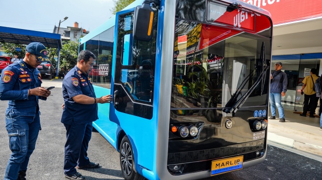Petugas memperhatikan purwarupa angkot listrik pintar saat diperkenalkan di Kantor Dinas Perhubungan Kota Bandung, Gedebage, Bandung, Jawa Barat, Senin (4/8/2025). [ANTARA FOTO/Raisan Al Farisi/nym]