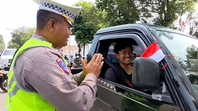 Jelang HUT RI ke-80, Satlantas Polresta Solo Bagikan Bendera Merah Putih ke Pengendara di Jalan