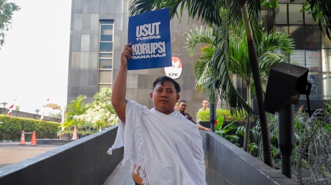 Pegiat antikorupsi dari Indonesia Corruption Watch (ICW) menggelar aksi seusai melaporkan kasus dugaan korupsi penyelenggaraan haji 1446H/2025 di Gedung Merah Putih KPK, Jakarta, Selasa (5/8/2025). [Suara.com/Alfian Winanto]