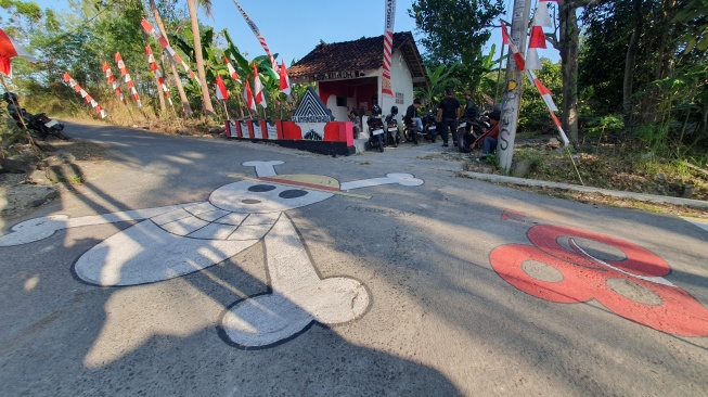 Potret mural One Piece di jalan kampung depan sebuah pos ronda RT 04 RW 22 Pedukuhan Temuwuh, Balecatur, Gamping, Sleman, Rabu (6/8/2025). [Hiskia/Suarajogja]