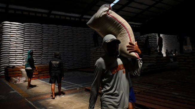 Pekerja mengangkut beras saat bongkar muat di gudang Bulog Cabang Cirebon, Jawa Barat, Rabu (6/8/2025). [ANTARA FOTO/Hafidz Mubarak A/rwa]