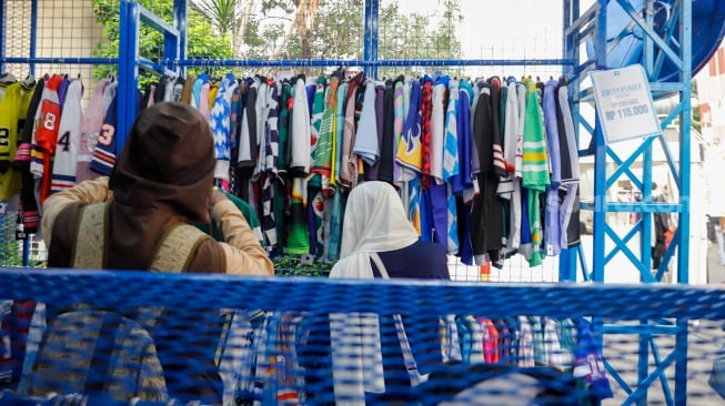 Pembeli memillih busana yang dijual dalam pameran JakCloth Summerfest 2025 di Blok M Hub, Jakarta, Sabtu (9/8/2025). [Suara.com/Alfian Winanto]