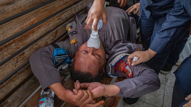 Tim kesehatan memberikan pertolongan pertama kepada personel kepolisian yang terluka usai mengamankan aksi unjuk rasa di depan Kantor Bupati Pati, Kabupaten Pati, Jawa Tengah, Rabu (13/8/2025). [ANTARA FOTO/Aji Styawan/nym]