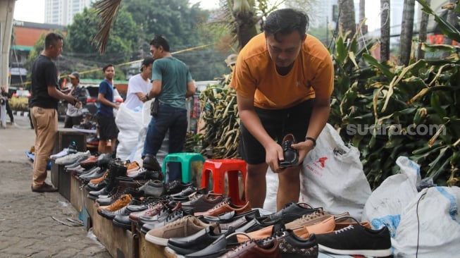 Pedagang menjajakan dagangannya pada lokasi bekas kebakaran di Pasar Taman Puring, Jakarta, Rabu (13/8/2025). [Suara.com/Alfian Winanto]