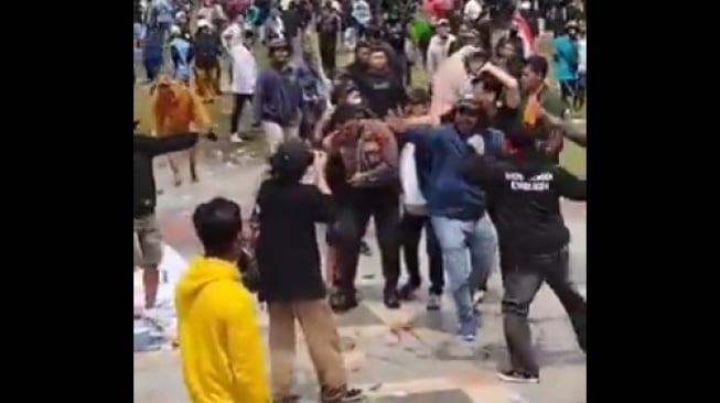 Tangkapan layar seorang polisi dikeroyok para pengunjuk rasa atau demo di Pati. [X/@Pandugaid]