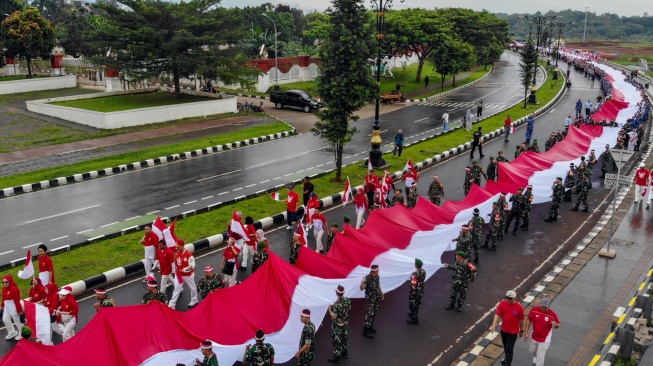 Foto udara peserta membentangkan Bendera Merah Putih dalam Kirab Merah Putih di Lingkar Stadion Pakansari, Kabupaten Bogor, Jawa Barat, Kamis (14/8/2025). [ANTARA FOTO/Yulius Satria Wijaya/nym]