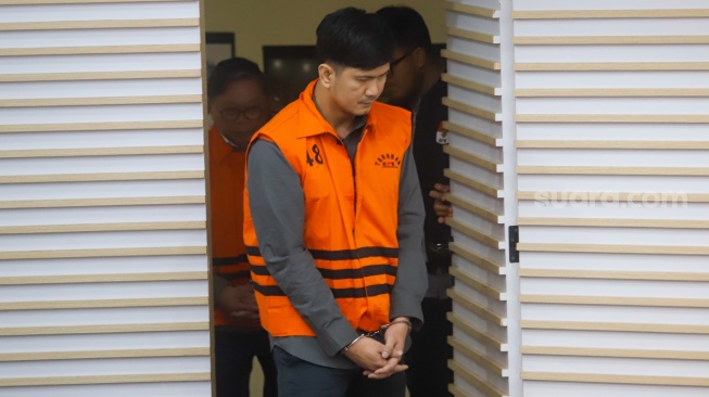 Staf Perizinan SB Grup, Aditya (tengah) mengenakan rompi tahanan usai terjaring Operasi Tangkap Tangan (OTT) di Gedung Merah Putih KPK, Jakarta, Kamis (14/8/2025). [Suara.com/Alfian Winanto]