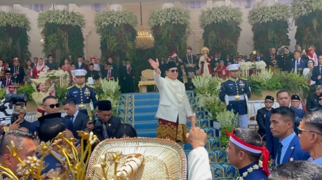 Presiden Prabowo Subianto menyapa warga yang ikut dalam Upacara Penaikan Bendera Merah Putih dalam rangka HUT ke-80 RI di Istana Merdeka, Jakarta, Minggu (17/8/2025). [Suara.com/Novian]