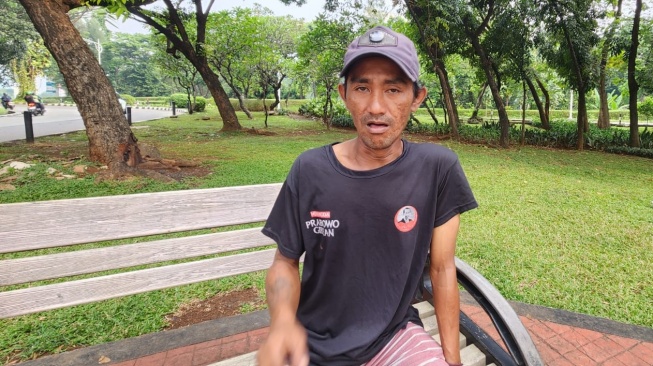 Pak Ogah dekat gedung DPR RI, Iwan. Ia merupakan salah satu korban PHK saat Pandemi Covid-19. Untuk menyambung hidup, ia memutuskan untuk bekerja menjadi pak ogah. [Suara,com/Fakhri]