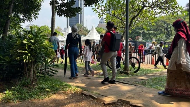 Warga berada di Kawasan sekitar Monas, Jakarta saat Perayaan Kemerdekaan Republik Indonesia. Mereka datang untuk menyaksikan berbagai macam penampilan di acara Pesta Rakyat. [Suara.com/Faqih]