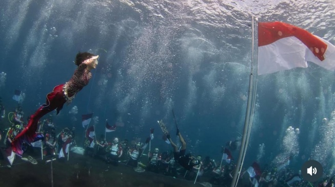 Menyambut Hari Ulang Tahun ke-80 Kemerdekaan Republik Indonesia, Gubernur Maluku Utara Sherly Tjoanda melakukan aksi pengibaran bendera Merah Putih di bawah laut [Suara.com/Instagram Sherly Tjoanda]