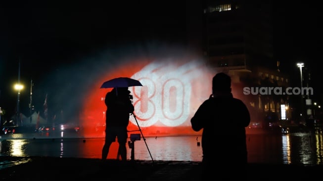 Warga menyaksikan pertunjukan water screen di Bundaran HI, Jakarta, Senin (18/8/2025). [Suara.com/Alfian Winanto]