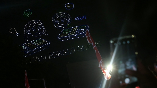 Warga mendokumentasikan atraksi formasi drone di Bundaran Hotel Indonesia, Jakarta, Minggu (17/8/2025). [ANTARA FOTO/Asprilla Dwi Adha/rwa]
