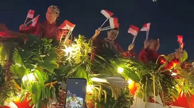 Menteri Keuangan Sri Mulyani berada di atas kendaraan hias dalam karnaval yang digelar di Kawasan Monas, Jakarta pada Minggu (18/8/2025) malam. [Tangkapan layar]