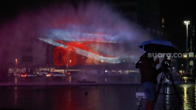 Warga menyaksikan pertunjukan water screen di Bundaran HI, Jakarta, Senin (18/8/2025). [Suara.com/Alfian Winanto]
