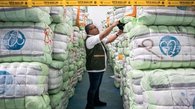 Petugas menunjukkan barang bukti pakaian bekas saat ekspose hasil pengawasan barang impor tidak sesuai ketentuan oleh Kementerian Perdagangan di Bojongsoang, Kabupaten Bandung, Jawa Barat, Selasa (19/8/2025). [ANTARA FOTO/Abdan Syakura/rwa]