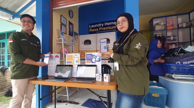 Sejumlah anak muda menunjukkan aplikasi 1010Dry yang telah digunakan oleh ribuan outlet laundry di Indonesia, Selasa (19/8/2025). [Hiskia/Suarajogja]