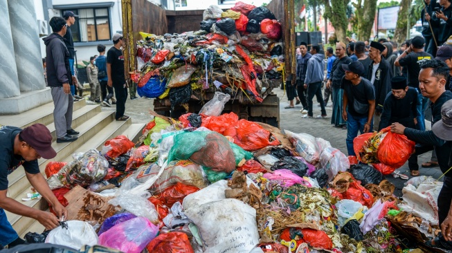 Sejumlah warga melakukan aksi buang sampah di depan pintu masuk Kantor Bupati Pandeglang, Pandeglang, Banten, Rabu (20/8/2025). [ANTARA FOTO/Muhammad Bagus Khoirunas/tom]