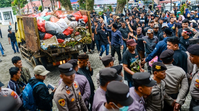 Sebuah truk sampah bersiap melakukan aksi buang sampah di depan pintu masuk Kantor Bupati Pandeglang, Pandeglang, Banten, Rabu (20/8/2025). [ANTARA FOTO/Muhammad Bagus Khoirunas/tom]