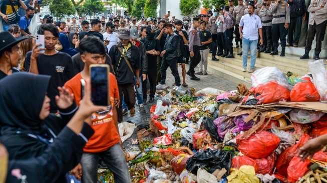 Anggota polisi berjaga saat warga melakukan aksi buang sampah di depan pintu masuk Kantor Bupati Pandeglang, Pandeglang, Banten, Rabu (20/8/2025). [ANTARA FOTO/Muhammad Bagus Khoirunas/tom]