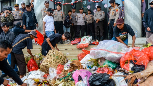 Anggota polisi berjaga saat sejumlah warga melakukan aksi buang sampah di depan pintu masuk Kantor Bupati Pandeglang, Pandeglang, Banten, Rabu (20/8/2025). [ANTARA FOTO/Muhammad Bagus Khoirunas/tom]