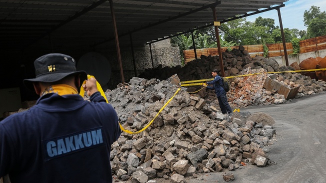 Petugas Penegakan Hukum (Gakkum) Kementerian Lingkungan Hidup memasang tanda garis larangan melintas dan plang penyegelan di area pabrik PT Genesis Regeneration Smelting, Jawilan, Kabupaten Serang, Banten, Kamis (21/8/2025). [Suara.com/Alfian Winanto]