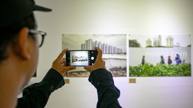 Pengunjung melihat foto yang dipamerkan pada pameran foto Rekam Jakarta 2025 di Cemara 6 Galeri, Jakarta, Sabtu (23/8/2025). [Suara.com/Alfian Winanto]